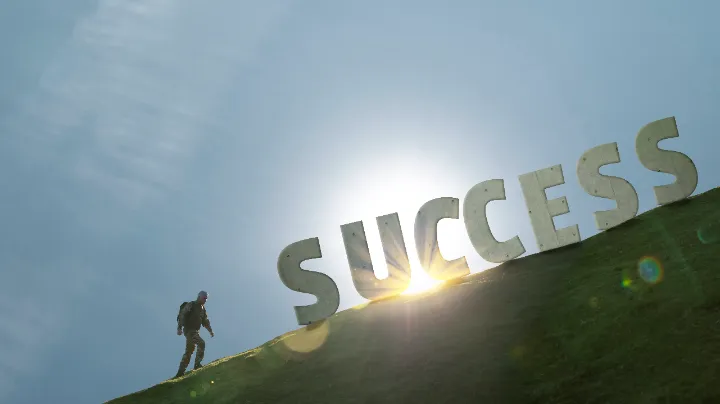 A professional climbing uphill toward giant 3D letters spelling "SUCCESS" with sunlight behind, symbolizing the journey and effort to become an outstanding recruitment agency.
